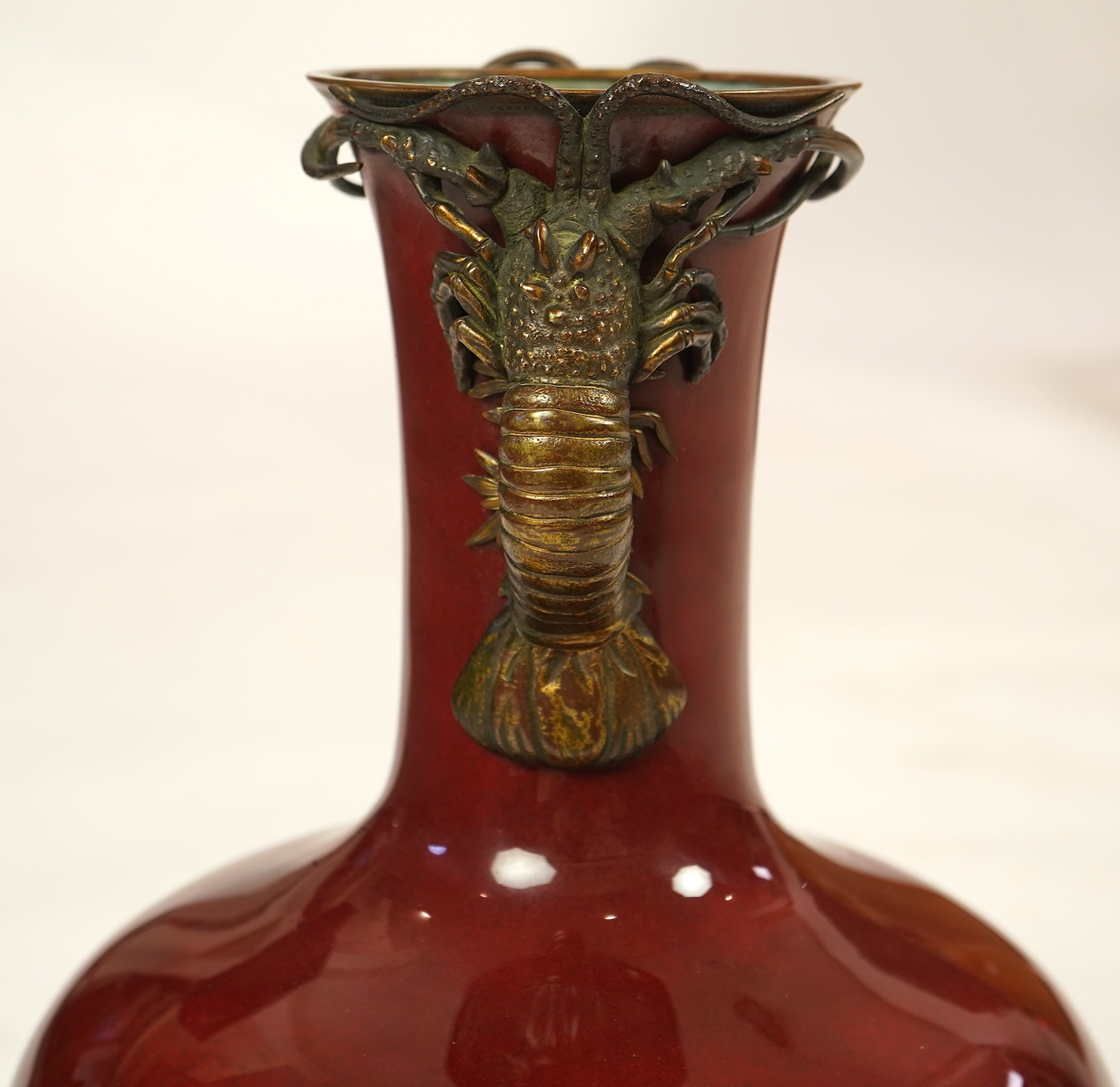 An unusual Japanese sang-de-boeuf ground cloisonné enamel and gilt metal mounted vase